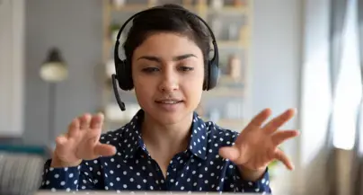 A student with headphones gestures.