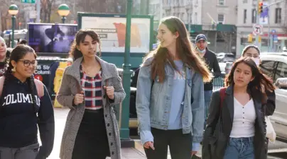 Four students walking past the Columbia subway stop