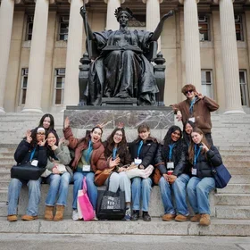 Students sitting in front of Alma Mater. (Photo: Sirin Samman)
