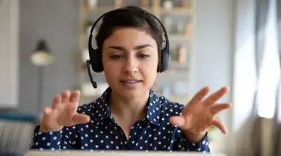 A student with headphones gestures.