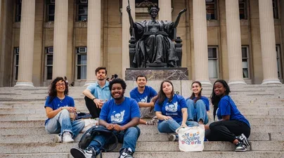 Pre College Staff members smiling in front of Columbia Alma Mater